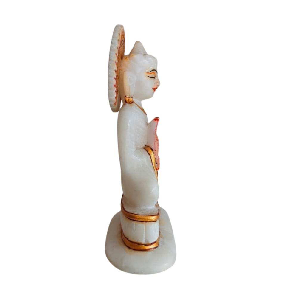 Serene white marble Buddha statue in meditation pose with gold highlights.