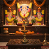 A golden brass traditional Indian oil lamp (Aishwarya Diya) on a stand, featuring a star-shaped deepak bowl and an ornate peacock figure at the top, against a light textured background.