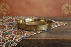 Traditional brass pooja thali with raised rim