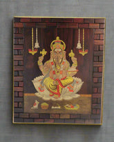 Decorative wall art of a seated figure with intricate details in a wooden frame.