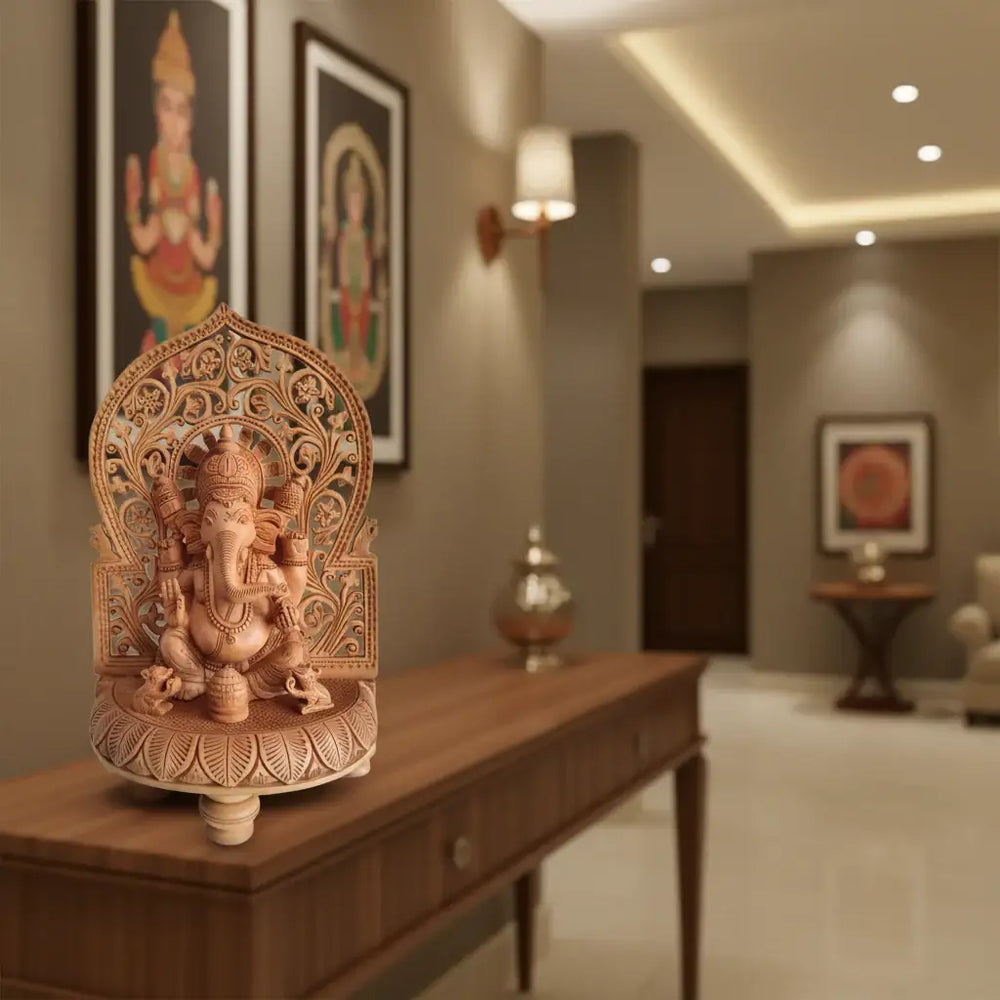 Intricately hand-carved wooden Ganesha idol seated on lotus base with floral prabhavali arch