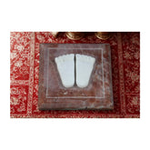 White stone feet sculpture on a red and gold decorative base