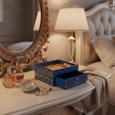 Royal blue wooden drawer box with a hand-painted lid showing a royal procession on an elephant, and intricate white and yellow patterns. The single drawer is pulled open.