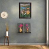 Decorative wall art with a clock and small table with a vase on a gray wall.