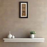 Miniature Painting Framed artwork above a white shelf with decorative vases and a small plant on a beige wall.