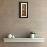 Miniature Painting Framed artwork above a white shelf with decorative vases and a small plant on a beige wall.