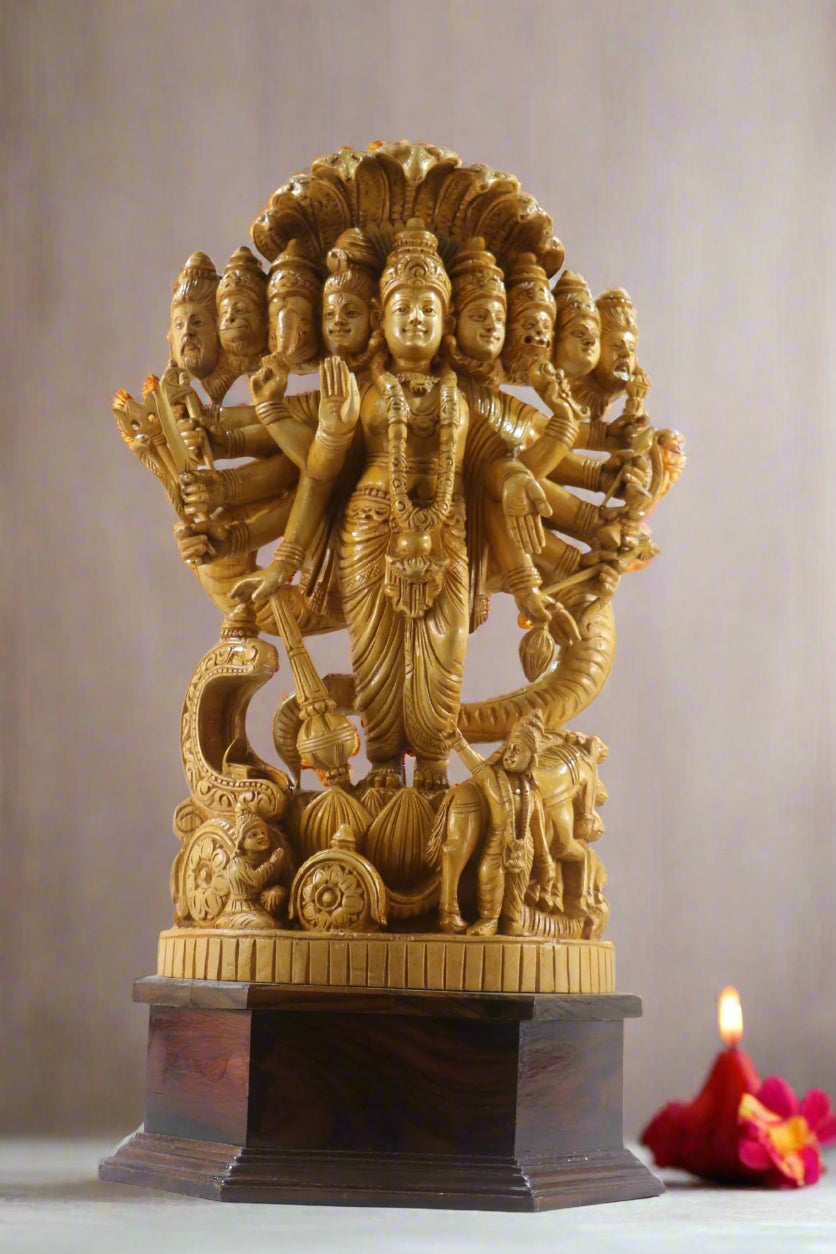 Gold-colored statue with multiple faces on a pedestal indoors