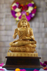 Wooden statue of a seated figure on a pedestal with 'Krafteria' branding in the background.