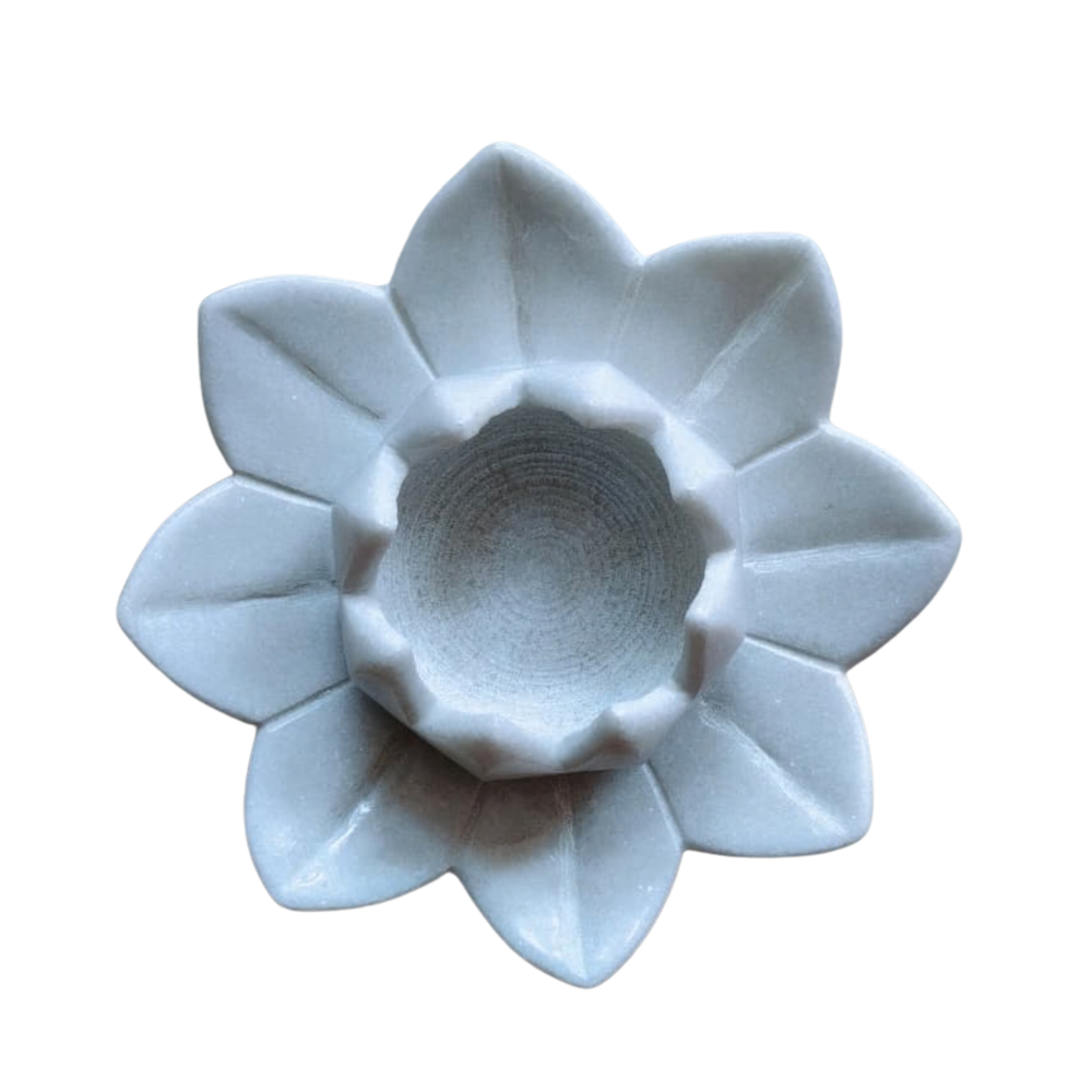 Decorative lotus-shaped marble candle holder for pooja room.
