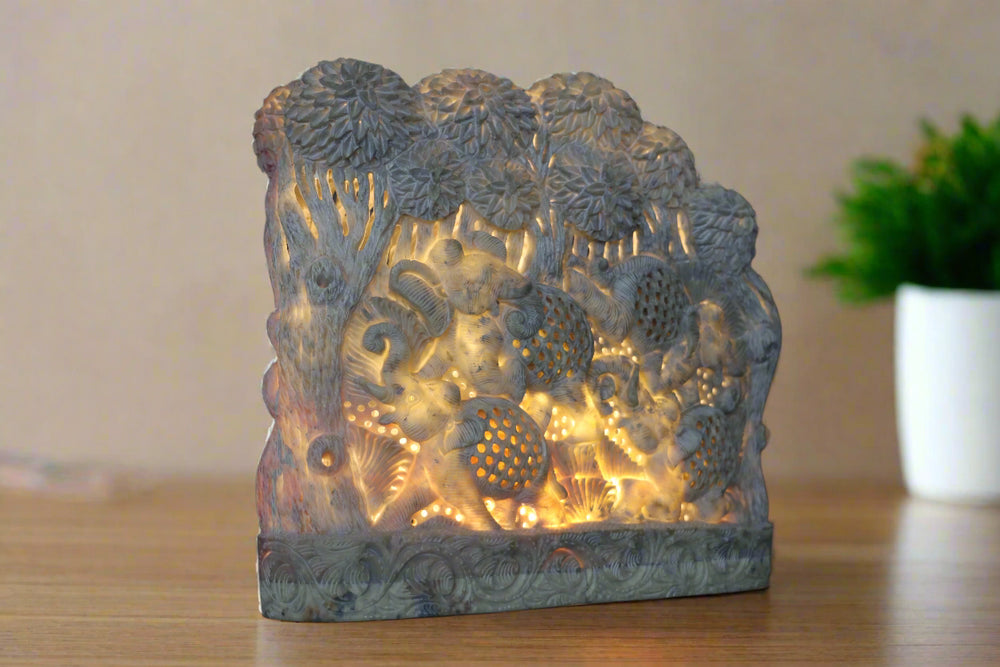 Decorative stone lamp with floral patterns on a wooden surface