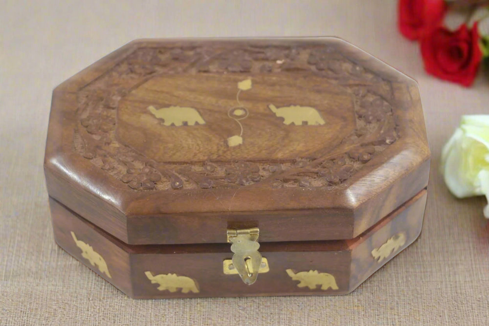 Wooden box with elephant carvings on a white background