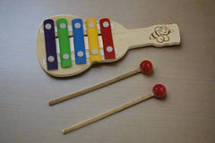 Wooden toy xylophone with colorful keys and two mallets on a white background