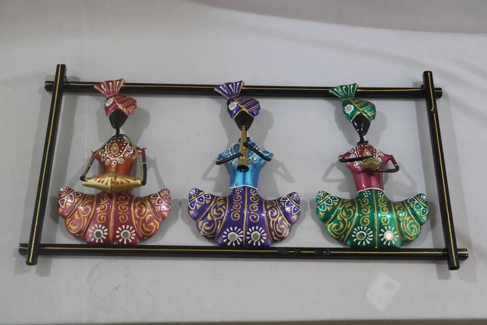 Decorative wall art with three colorful figurines on a white background