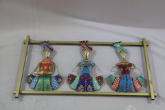 Decorative wall art with colorful figures on a gold stand against a white background