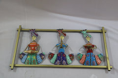 Decorative wall art with colorful figures on a gold stand against a white background