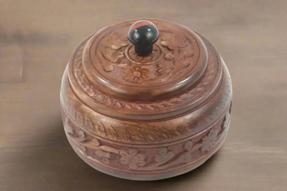 Wooden box with intricate carvings on a white background