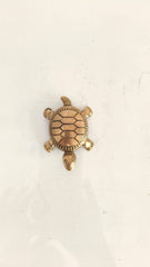 Small bronze turtle figurine with detailed shell pattern on a white background.