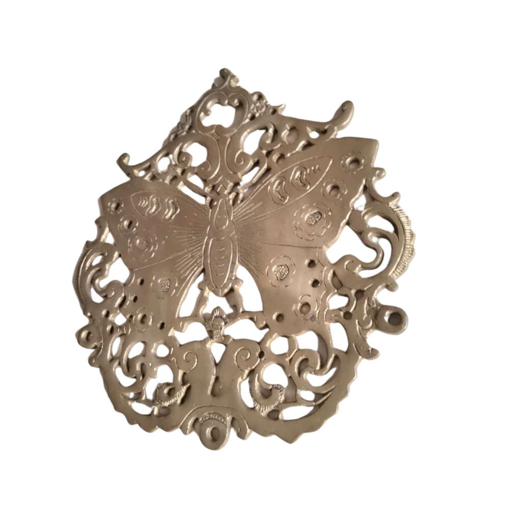 Vintage brass butterfly wall decor with intricate filigree medallion detail.