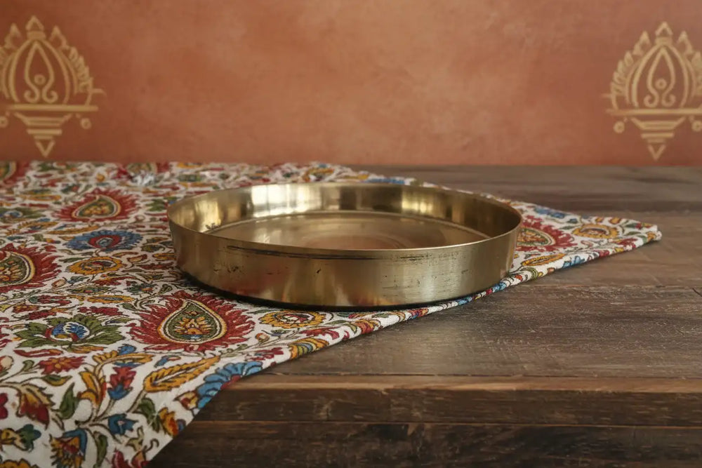 Traditional brass pooja thali with raised rim
