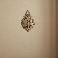 Vintage-style brass butterfly wall decor with intricate filigree medallion.