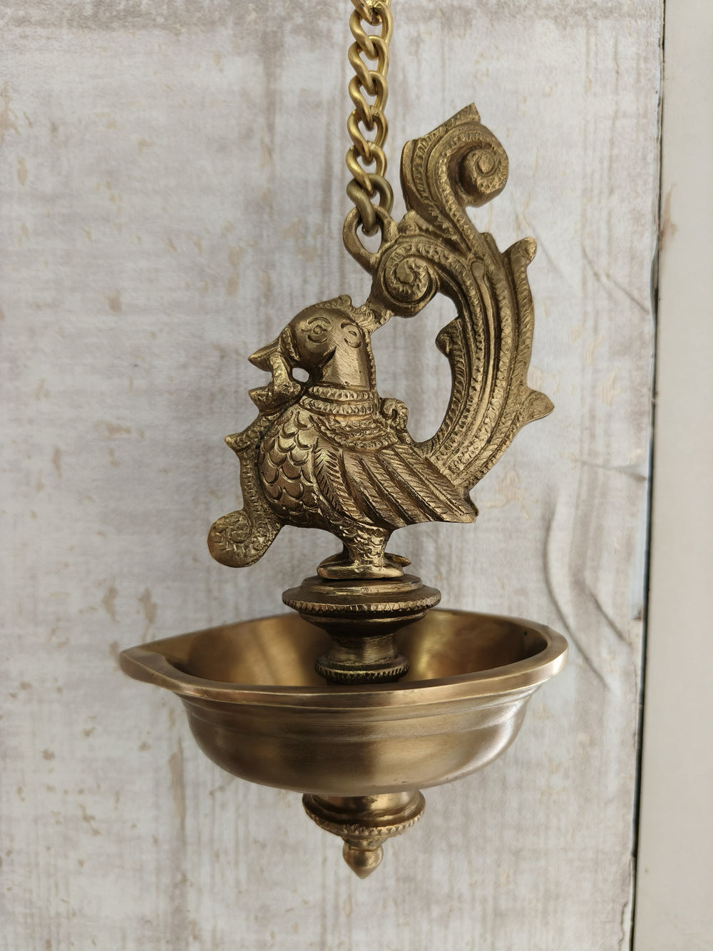 Brass peacock hanging diya, a decorative lamp featuring intricate peacock designs, ideal for festive celebrations.